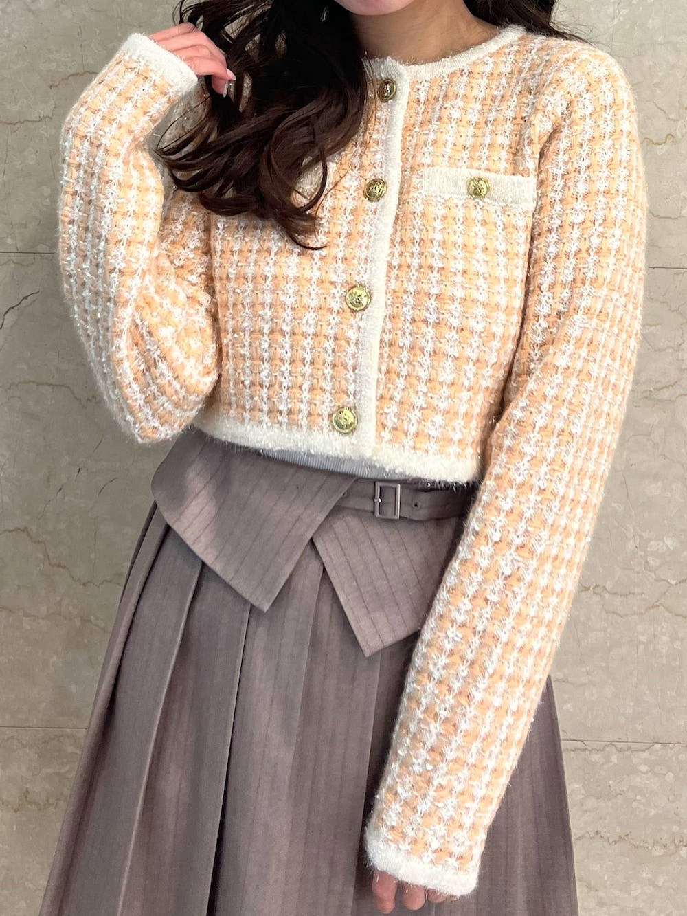 オレンジ系のノーカラージャケット、ベージュ系のスカート、ホワイト系のブーツを着用したレディースの冬コーディネートの8枚目の写真