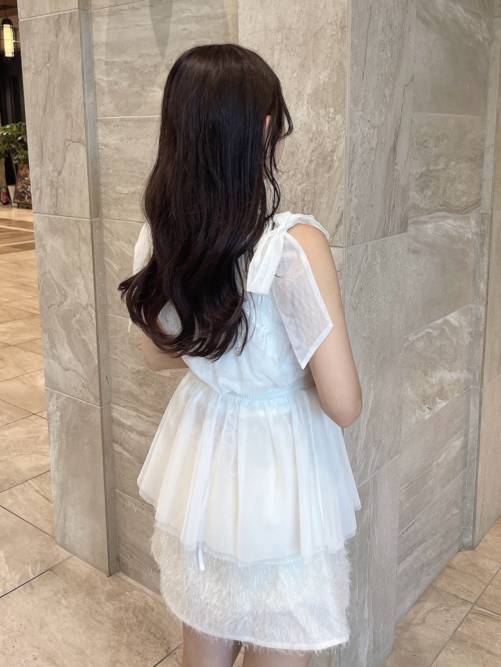 ホワイト系のニット/セーター、ホワイト系のタンクトップ、ホワイト系のスカートを着用したレディースの夏コーディネートの7枚目の写真