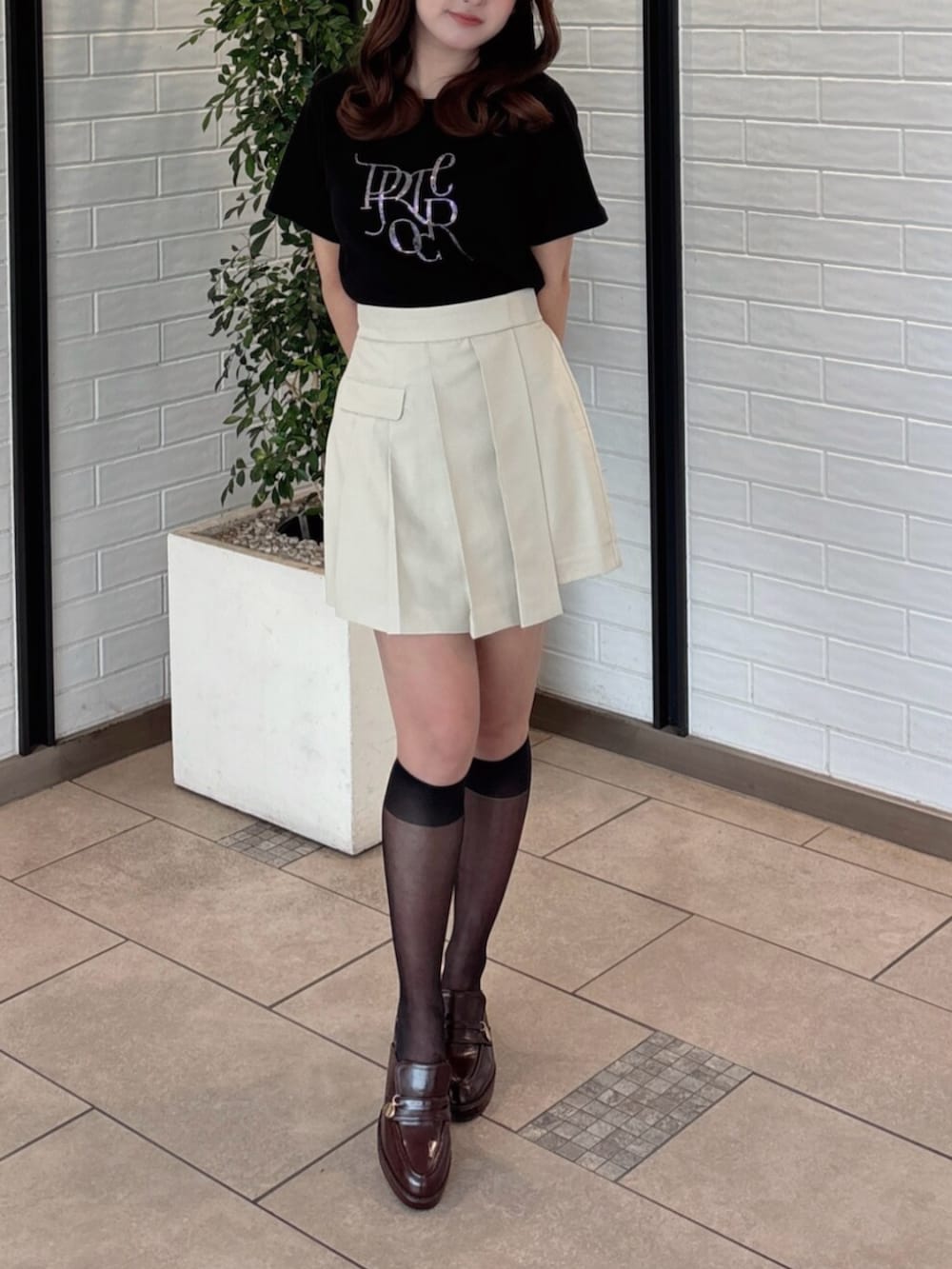 ブラウン系のパンプス、ブラック系のTシャツ/カットソー、ベージュ系のスカートを着用したレディースの夏コーディネートの4枚目の写真