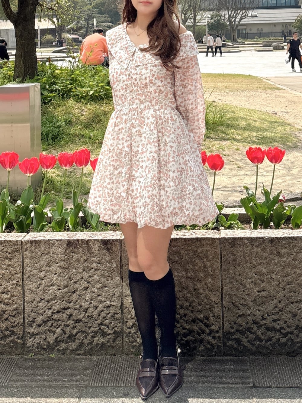 オレンジ系のワンピース、ブラウン系のローファーを着用したレディースの春コーディネートの6枚目の写真