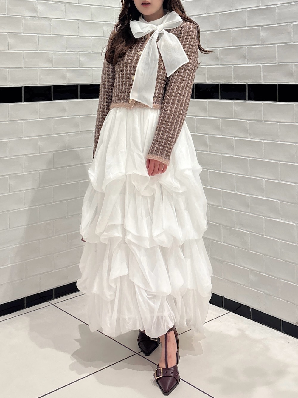 ブラウン系のカーディガン/ボレロ、ホワイト系のシャツ/ブラウス、ブラウン系のショルダーバッグを着用したレディースの秋コーディネートの5枚目の写真