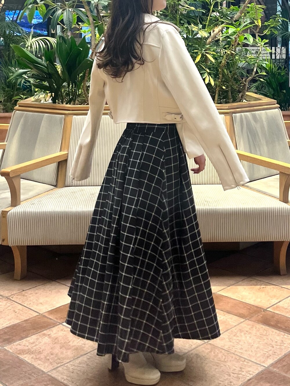 ホワイト系のライダースジャケット、ホワイト系のニット/セーター、ブラック系のスカートを着用したレディースの春コーディネートの8枚目の写真