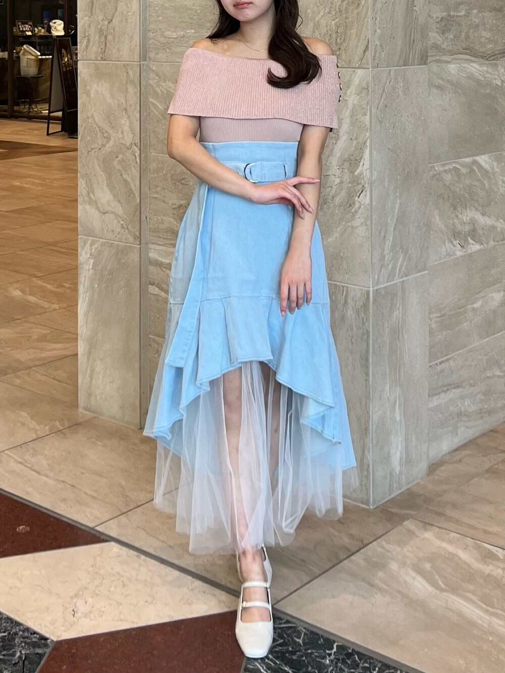 ピンク系のニット/セーター、ブルー系のスカート、ホワイト系のパンプスを着用したレディースの夏コーディネートの4枚目の写真