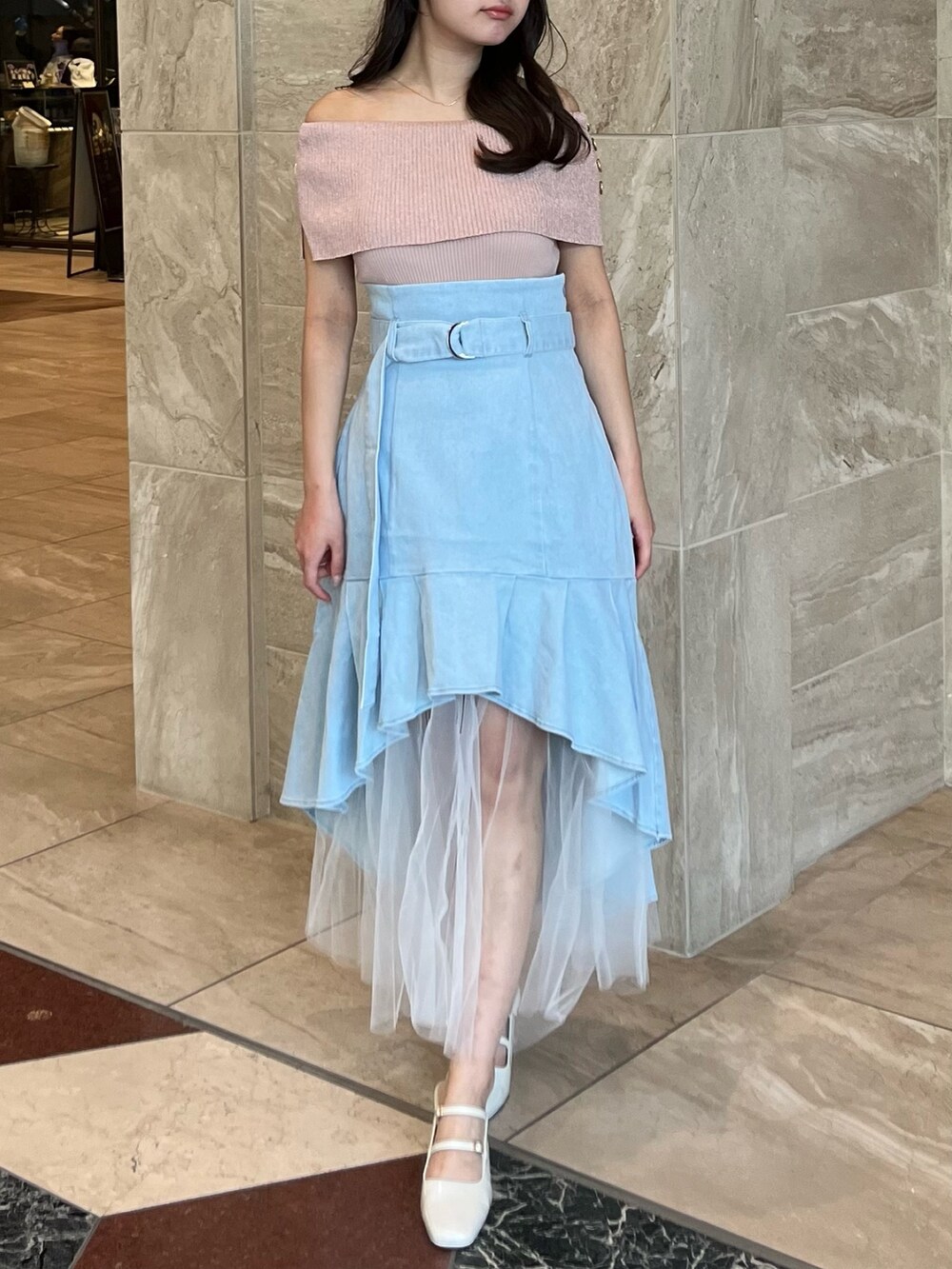 ピンク系のニット/セーター、ブルー系のスカート、ホワイト系のパンプスを着用したレディースの夏コーディネートの5枚目の写真