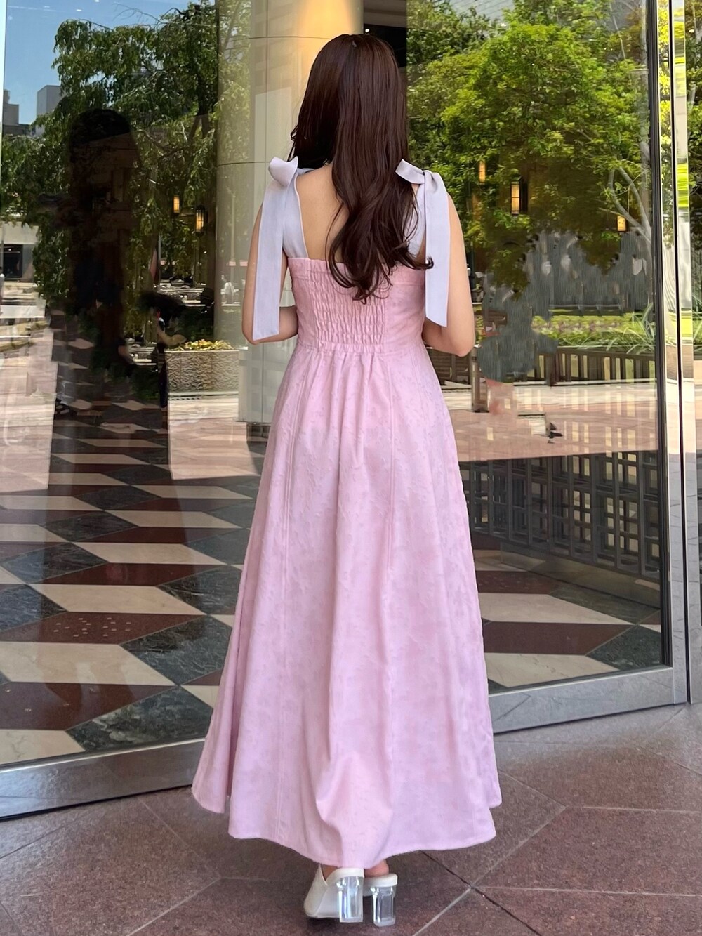 ピンク系のワンピース、ホワイト系のパンプスを着用したレディースの夏コーディネートの7枚目の写真