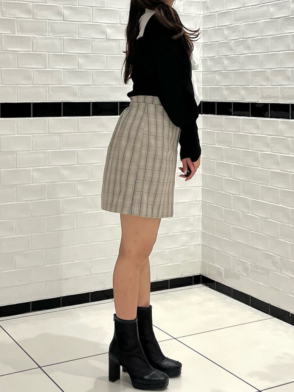 ブラック系のニット/セーター、その他のスカート、ブラック系のブーツを着用したレディースの冬コーディネートの5枚目の写真