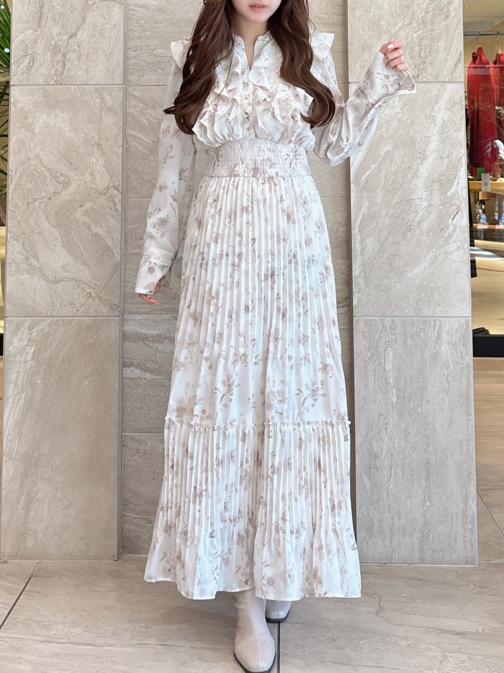 ホワイト系のワンピース、ベージュ系のブーツを着用したレディースの冬コーディネートの6枚目の写真