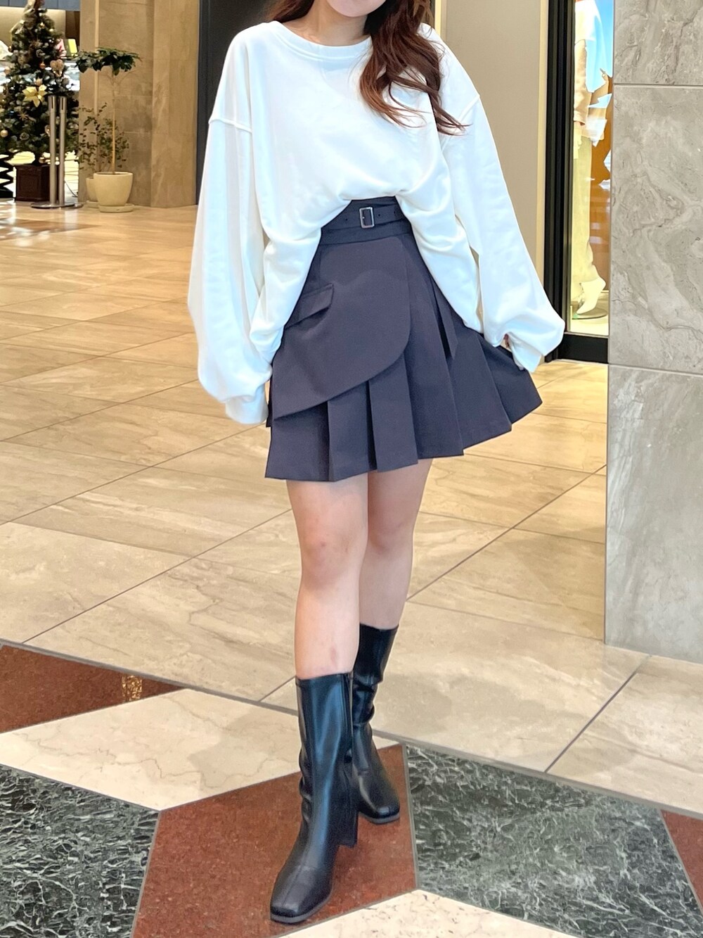 ホワイト系のTシャツ/カットソー、グレー系のスカート、ブラック系のブーツを着用したレディースの冬コーディネートの3枚目の写真