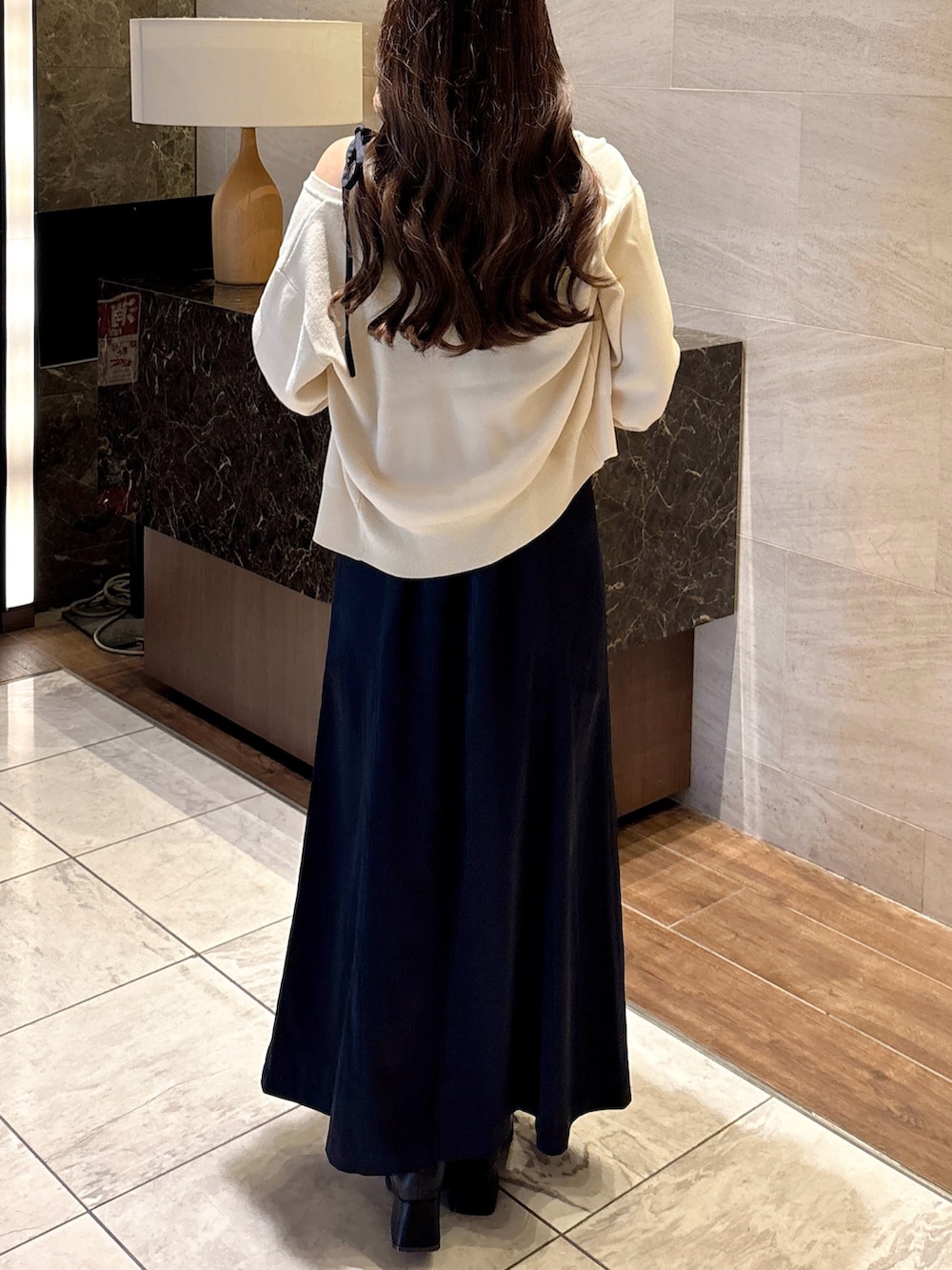 ブルー系のワンピース、ホワイト系のカーディガン/ボレロ、ブラック系のパンプスを着用したレディースの秋コーディネートの7枚目の写真