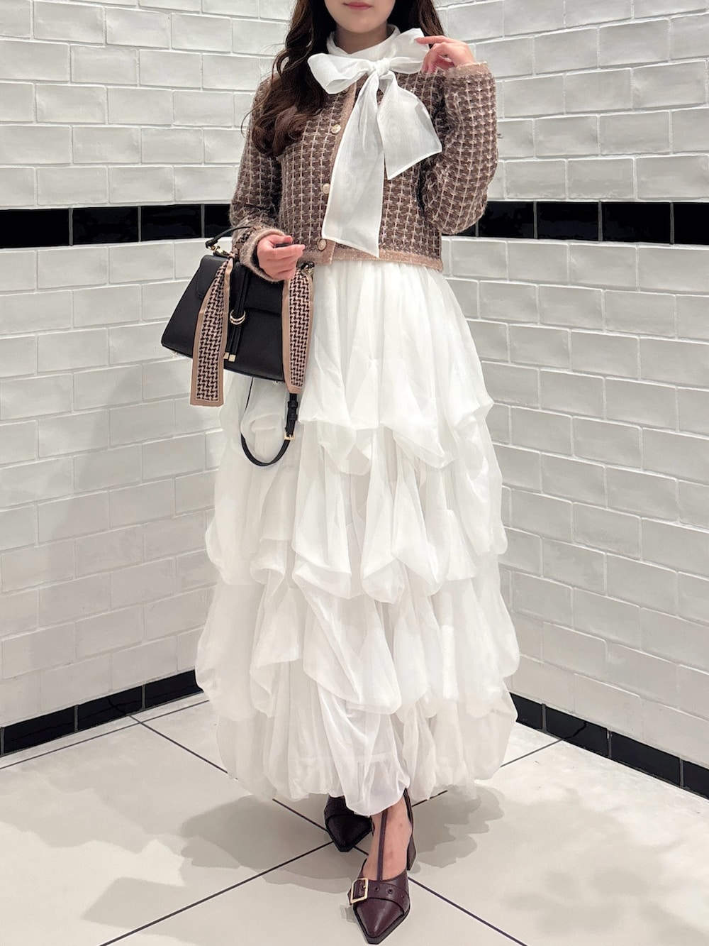 ブラウン系のカーディガン/ボレロ、ホワイト系のシャツ/ブラウス、ブラウン系のショルダーバッグを着用したレディースの秋コーディネートの3枚目の写真