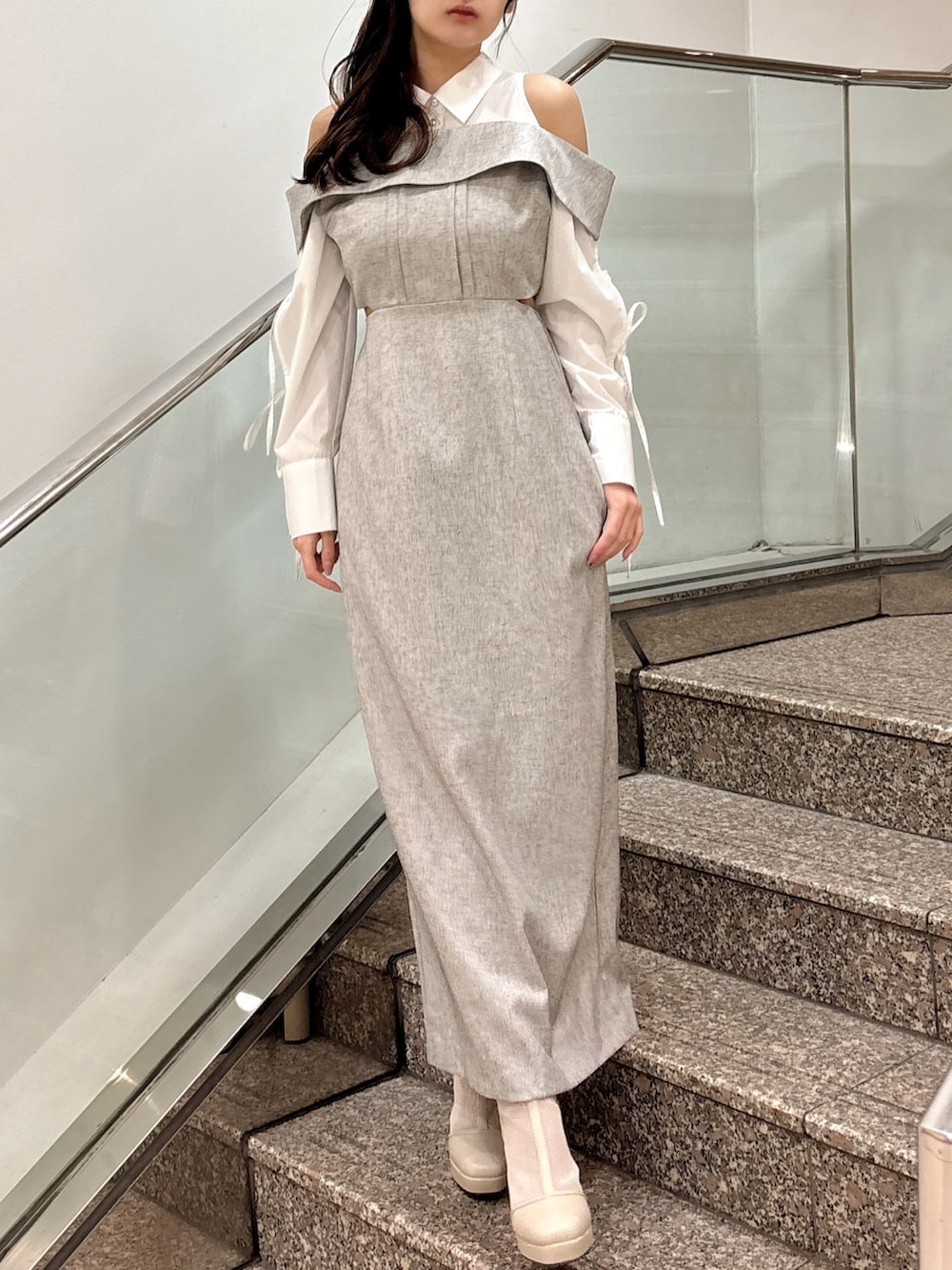 グレー系のワンピース、ベージュ系のブーツを着用したレディースの春コーディネートの3枚目の写真