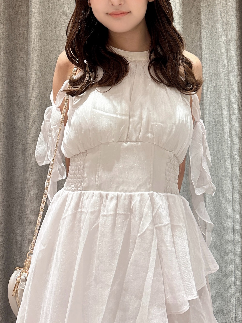 ピンク系のワンピース、シルバー系のショルダーバッグ、ホワイト系のパンプスを着用したレディースの夏コーディネートの9枚目の写真