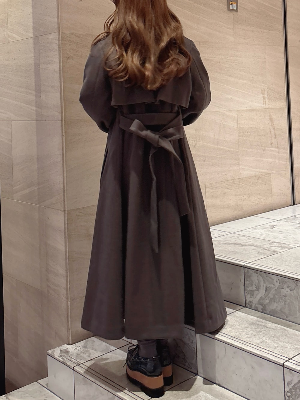 ブラウン系のトレンチコート、ブルー系のワンピース、その他のローファーを着用したレディースの秋コーディネートの7枚目の写真