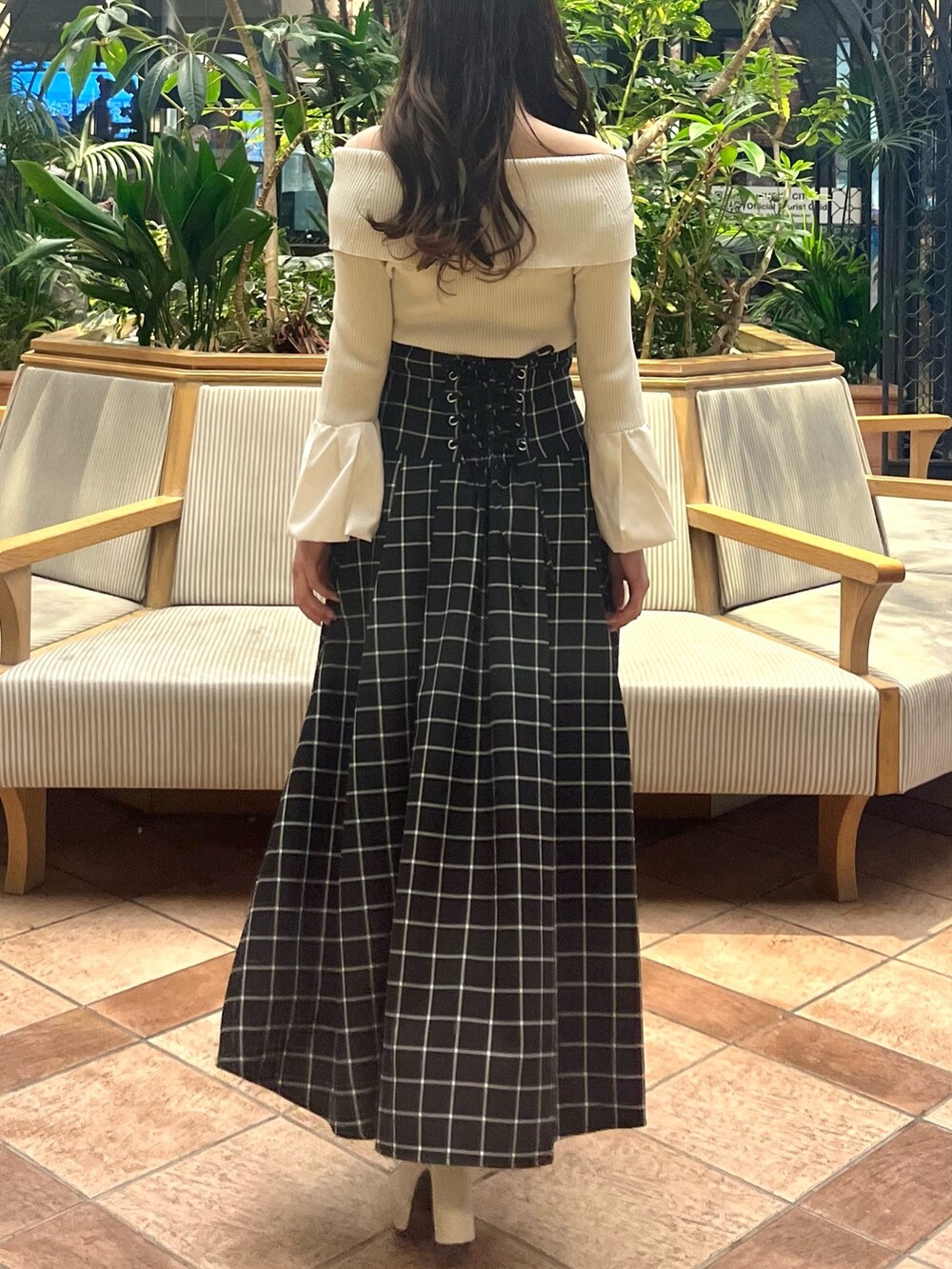 ホワイト系のニット/セーター、ブラック系のスカート、ホワイト系のブーツを着用したレディースの春コーディネートの8枚目の写真