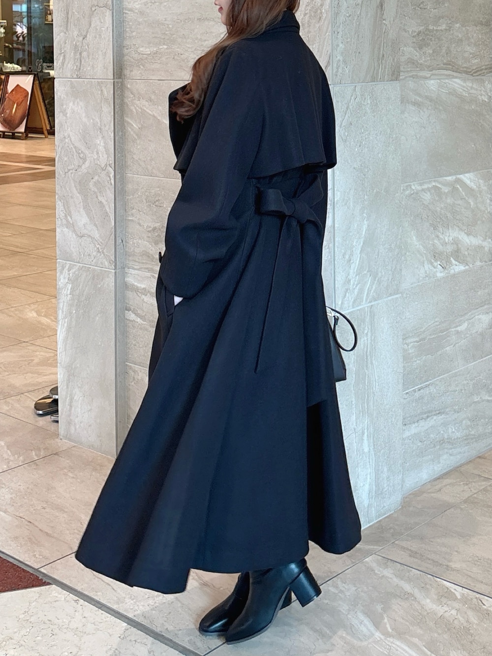 ブラック系のニット/セーター、ブラック系のスカート、ブラウン系のショルダーバッグを着用したレディースの秋コーディネートの4枚目の写真