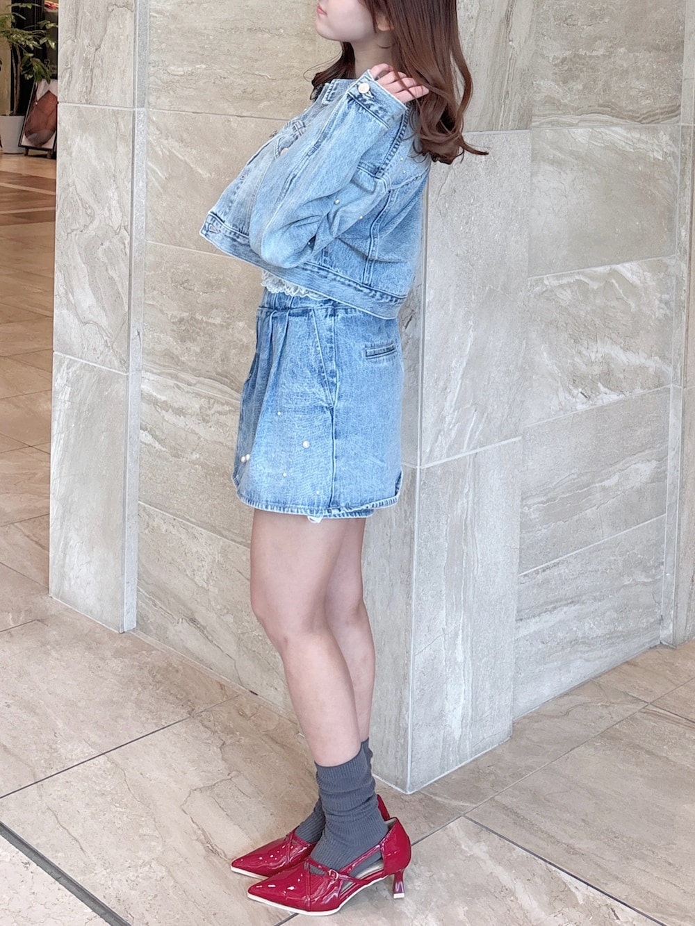 ブルー系のデニムジャケット、ブルー系のデニムパンツ、ホワイト系のキャミソールを着用したレディースの春コーディネートの7枚目の写真