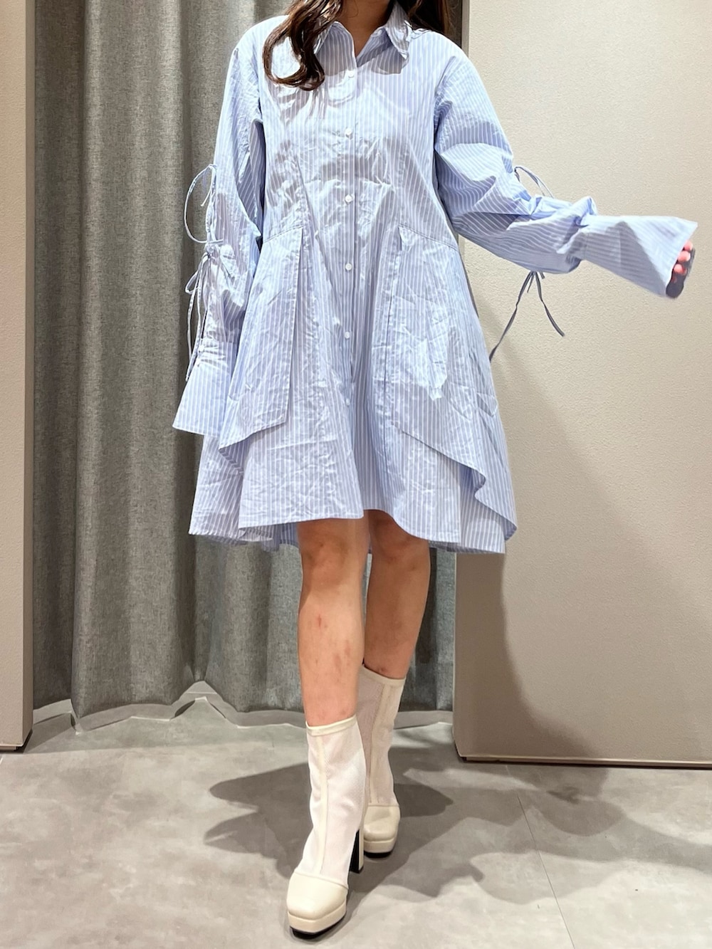 ブルー系のシャツワンピース、ホワイト系のブーツを着用したレディースの冬コーディネートの4枚目の写真