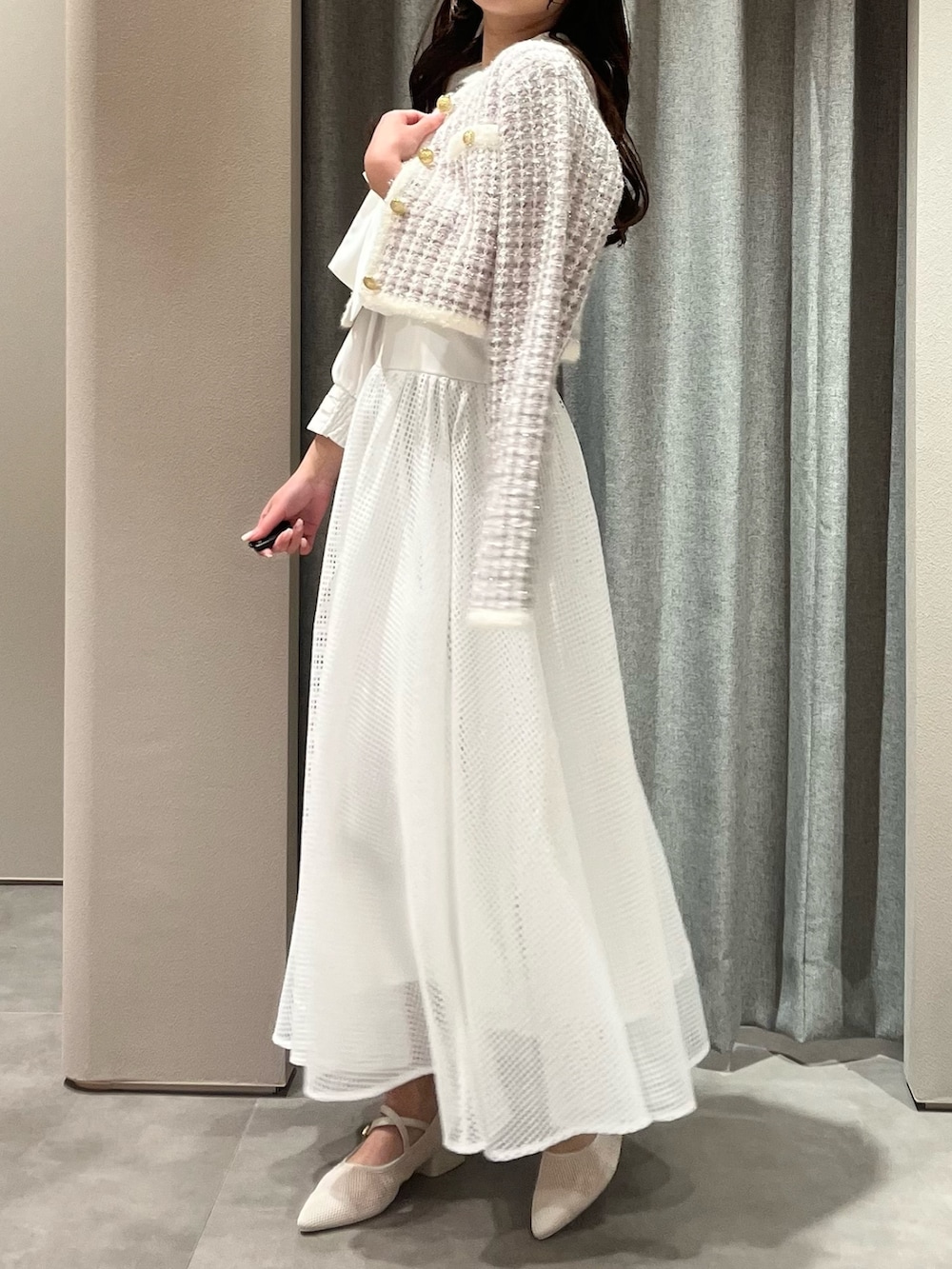 パープル系のノーカラージャケット、ホワイト系のワンピース、ホワイト系のパンプスを着用したレディースの春コーディネートの6枚目の写真