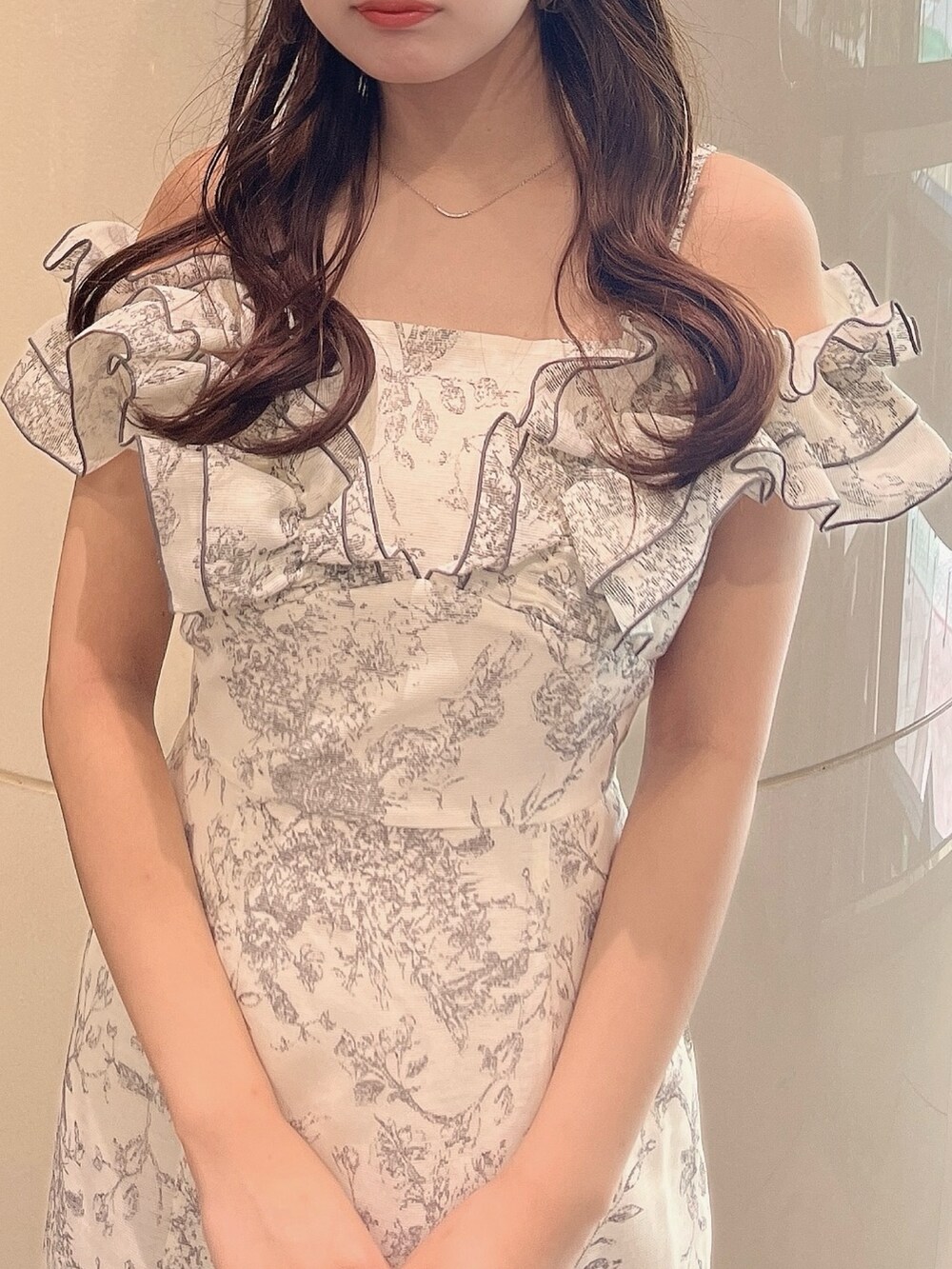 ホワイト系のワンピース、シルバー系のパンプスを着用したレディースの夏コーディネートの6枚目の写真