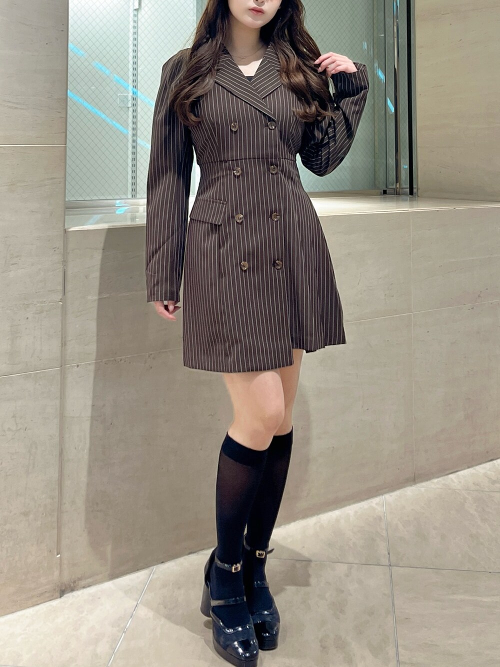 ブラック系のパンプス、ブラウン系のワンピースを着用したレディースの秋コーディネートの2枚目の写真