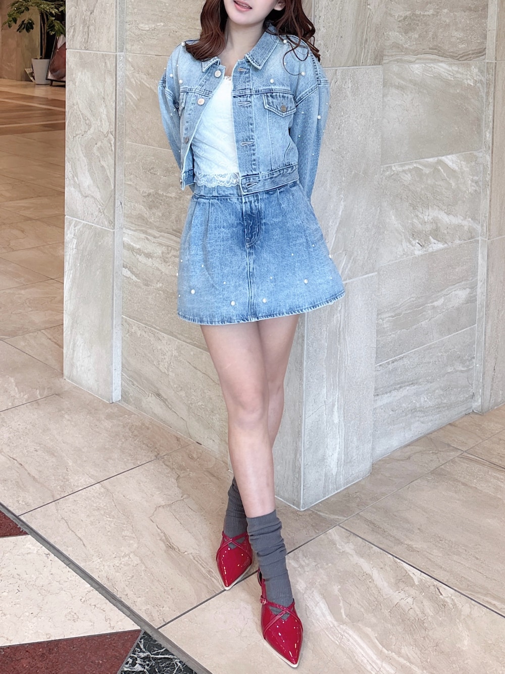 ブルー系のデニムジャケット、ブルー系のデニムパンツ、ホワイト系のキャミソールを着用したレディースの春コーディネートの2枚目の写真