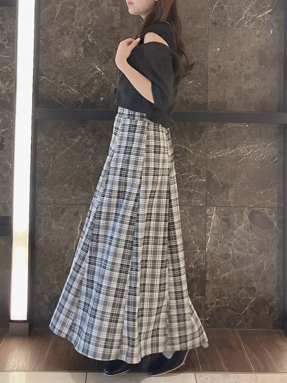 グレー系のニット/セーター、ブラック系のワンピース、ブラック系のパンプスを着用したレディースの夏コーディネートの2枚目の写真