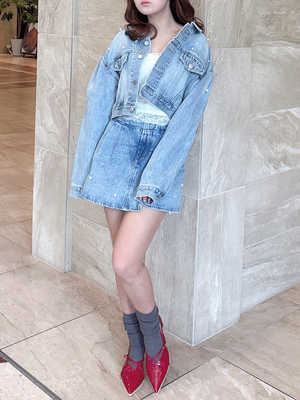 ブルー系のデニムジャケット、ブルー系のデニムパンツ、ホワイト系のキャミソールを着用したレディースの春コーディネートの3枚目の写真