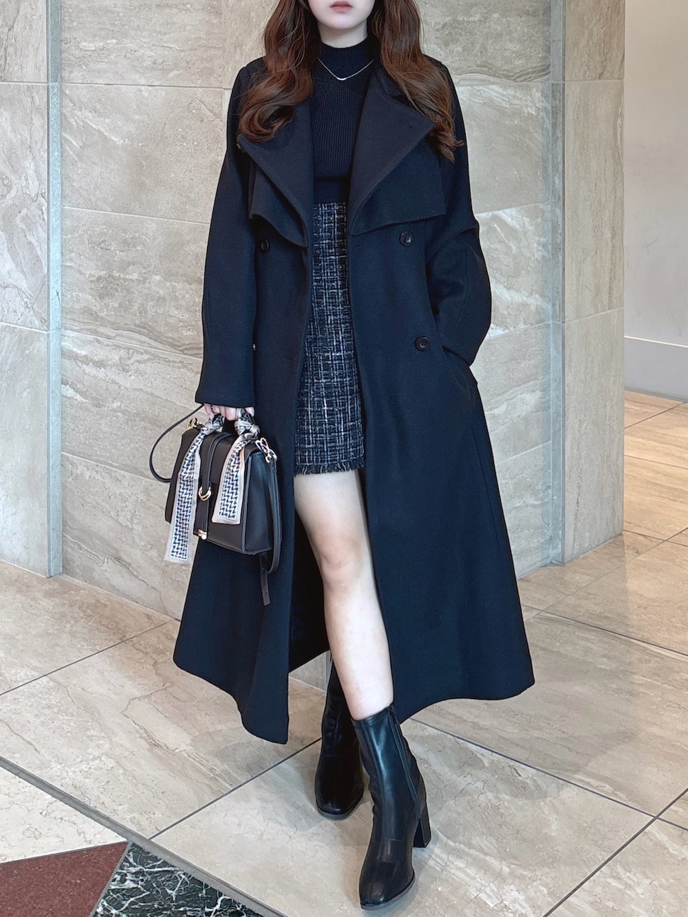 ブラック系のニット/セーター、ブラック系のスカート、ブラウン系のショルダーバッグを着用したレディースの秋コーディネートの3枚目の写真