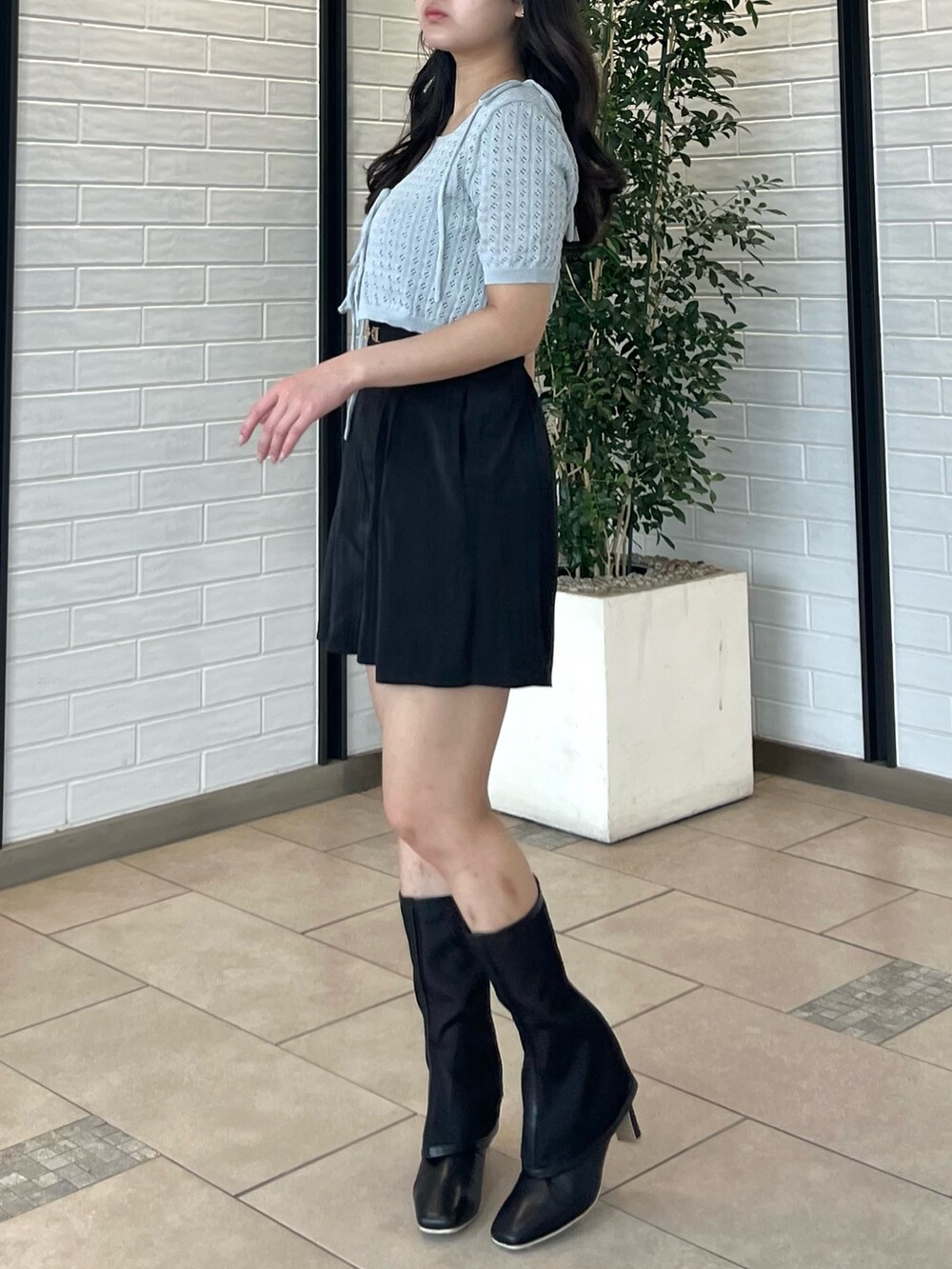 グレー系のニット/セーター、ブラック系のその他パンツ、ブラック系のブーツを着用したレディースの夏コーディネートの4枚目の写真