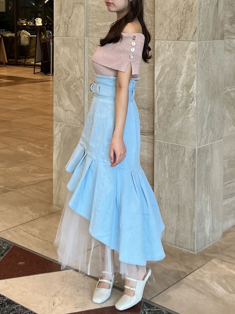 ピンク系のニット/セーター、ブルー系のスカート、ホワイト系のパンプスを着用したレディースの夏コーディネートの7枚目の写真