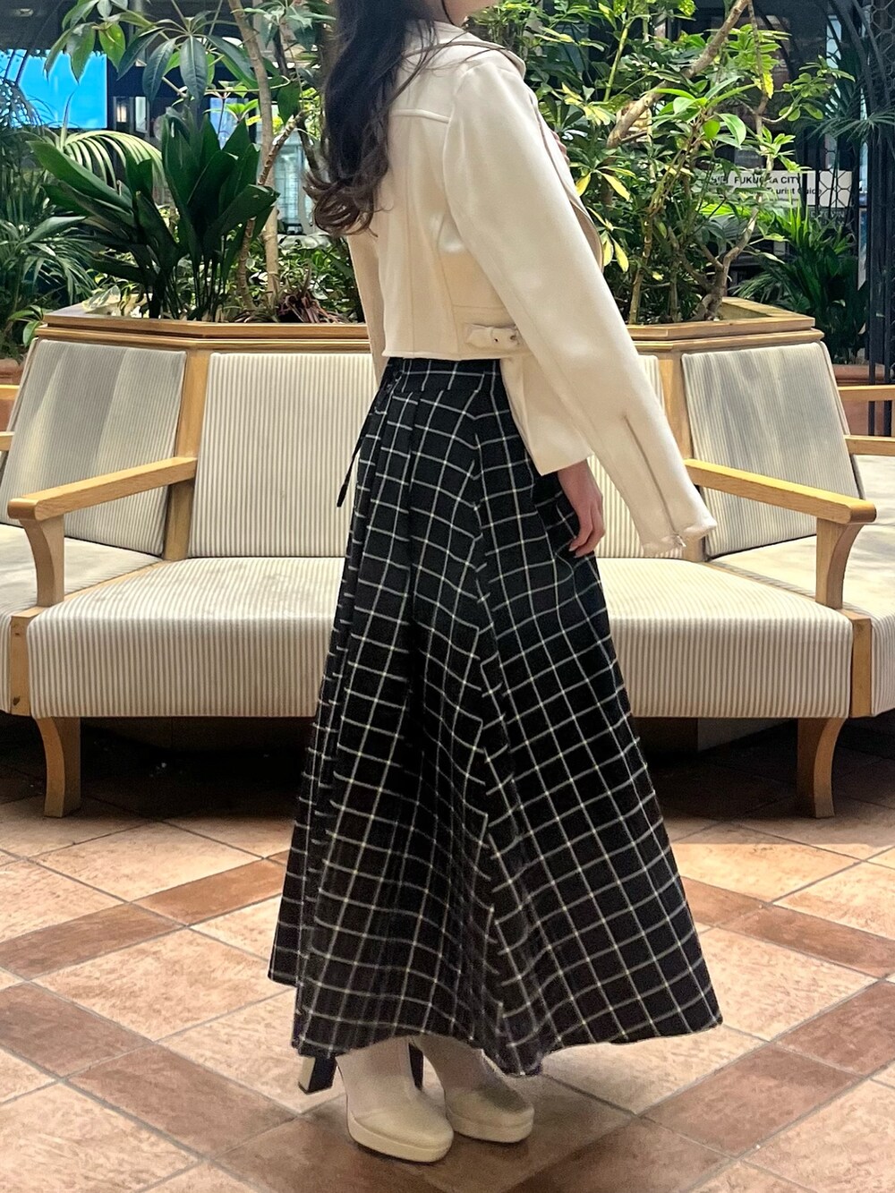 ホワイト系のライダースジャケット、ホワイト系のニット/セーター、ブラック系のスカートを着用したレディースの春コーディネートの7枚目の写真