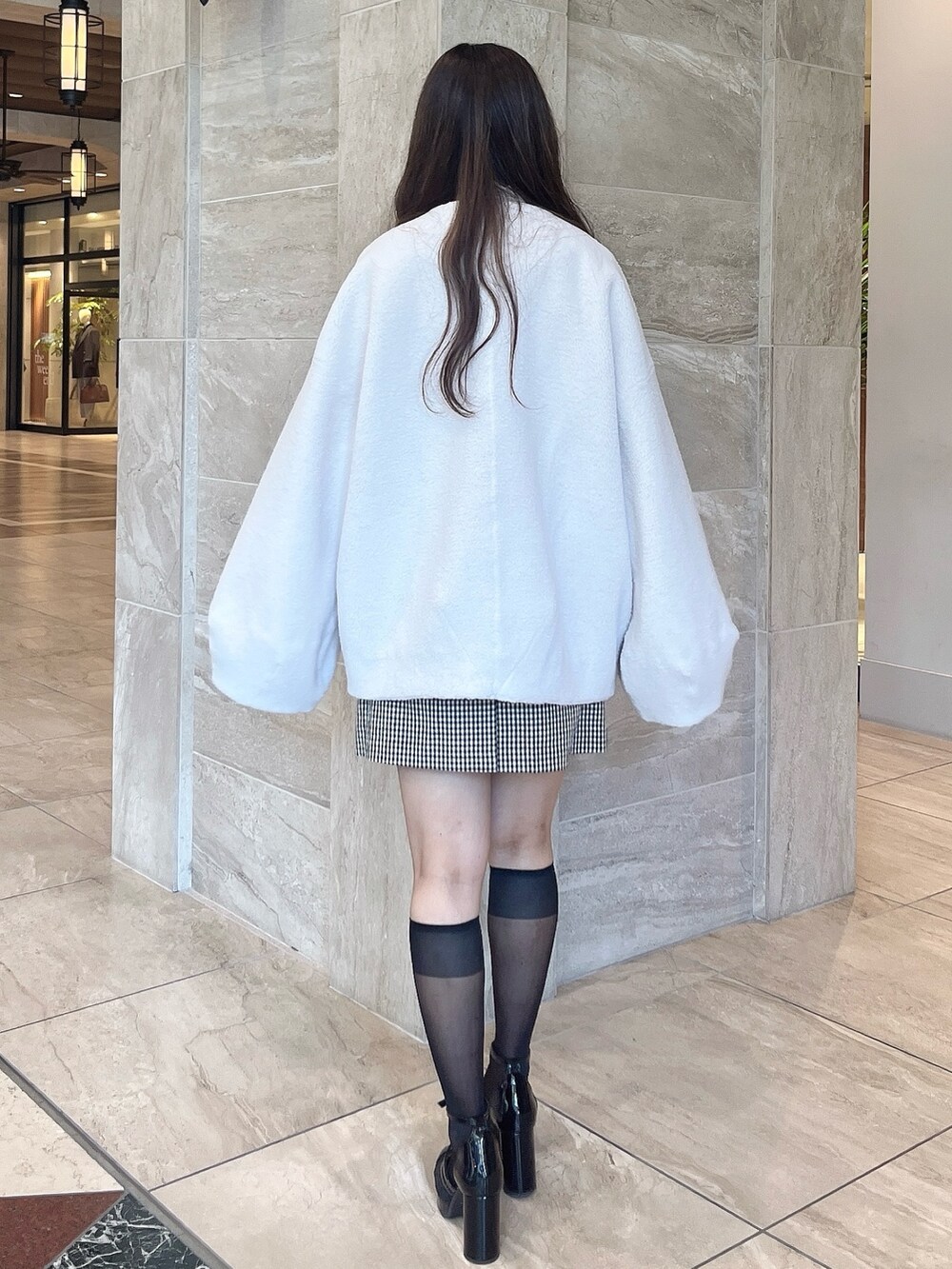 ホワイト系のその他アウター、その他のスカート、ブラック系のパンプスを着用したレディースの秋コーディネートの8枚目の写真