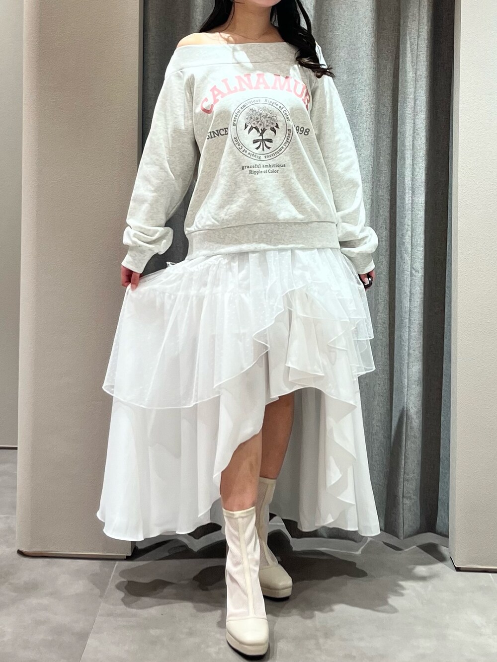 グレー系のスウェット、ホワイト系のスカート、ホワイト系のブーツを着用したレディースの春コーディネートの3枚目の写真