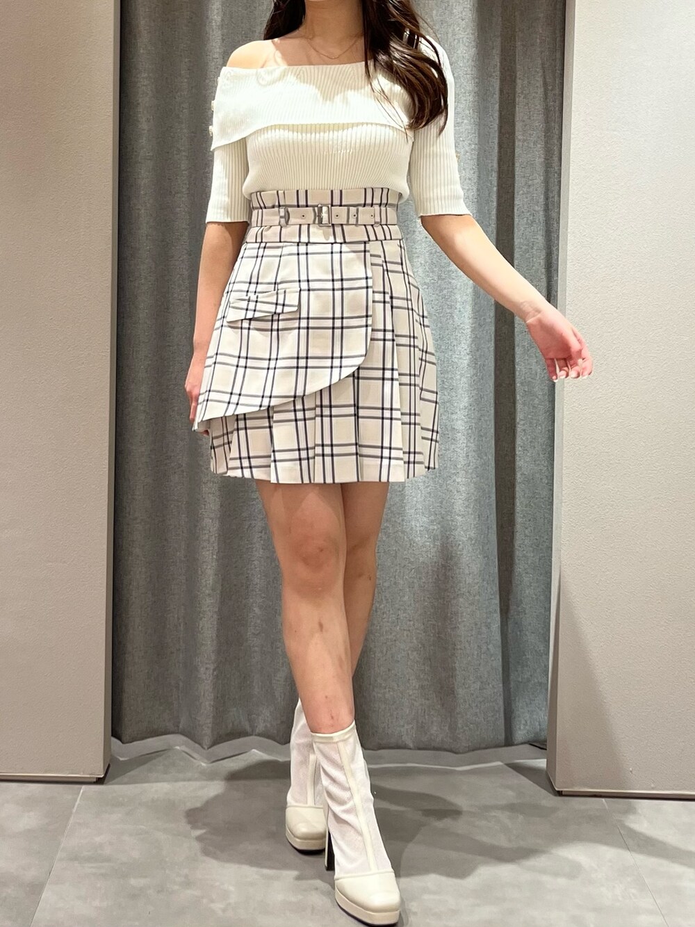ホワイト系のニット/セーター、ベージュ系のスカート、ホワイト系のブーツを着用したレディースの春コーディネートの3枚目の写真
