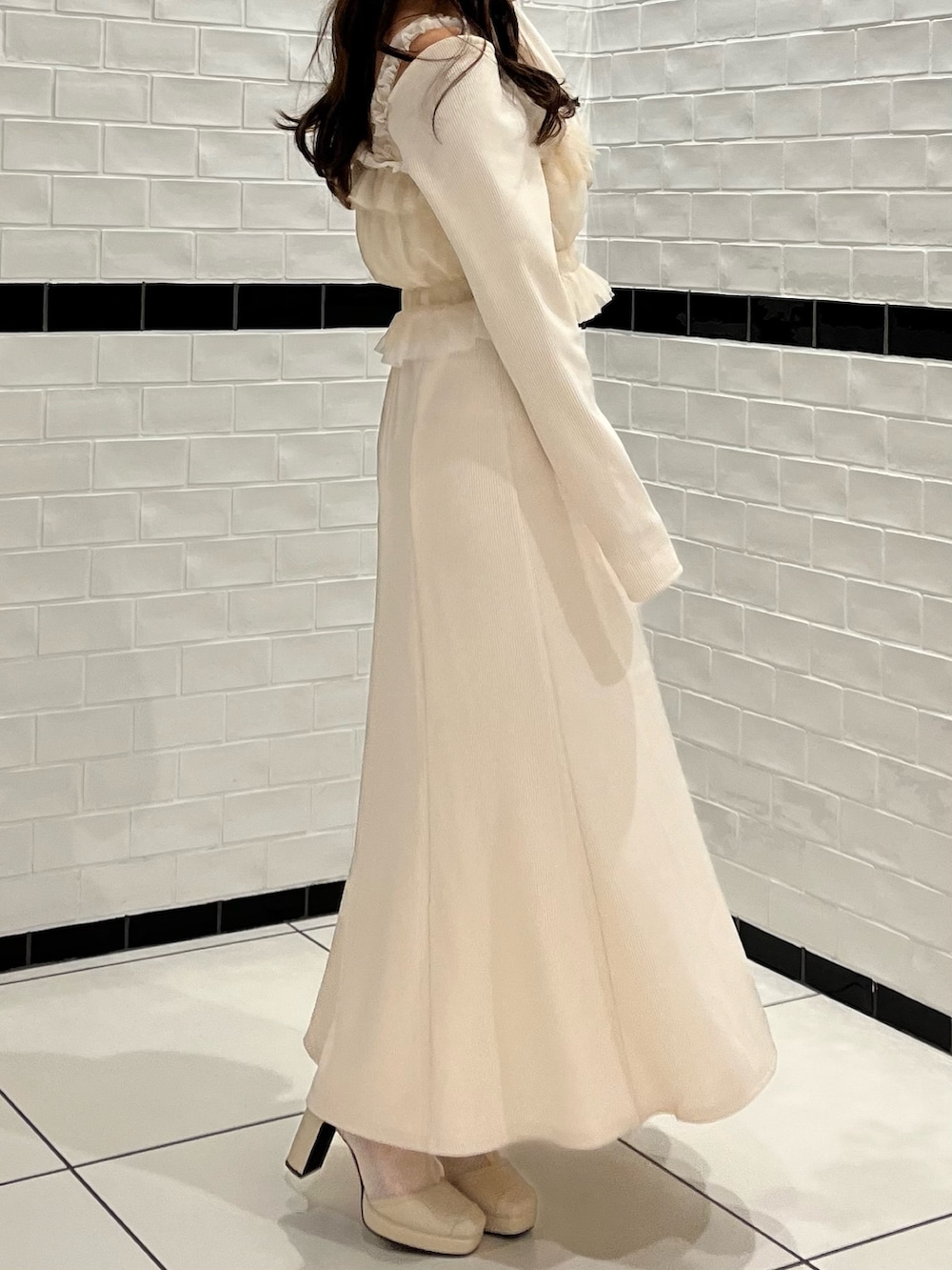 ホワイト系のワンピース、ホワイト系のブーツを着用したレディースの冬コーディネートの6枚目の写真