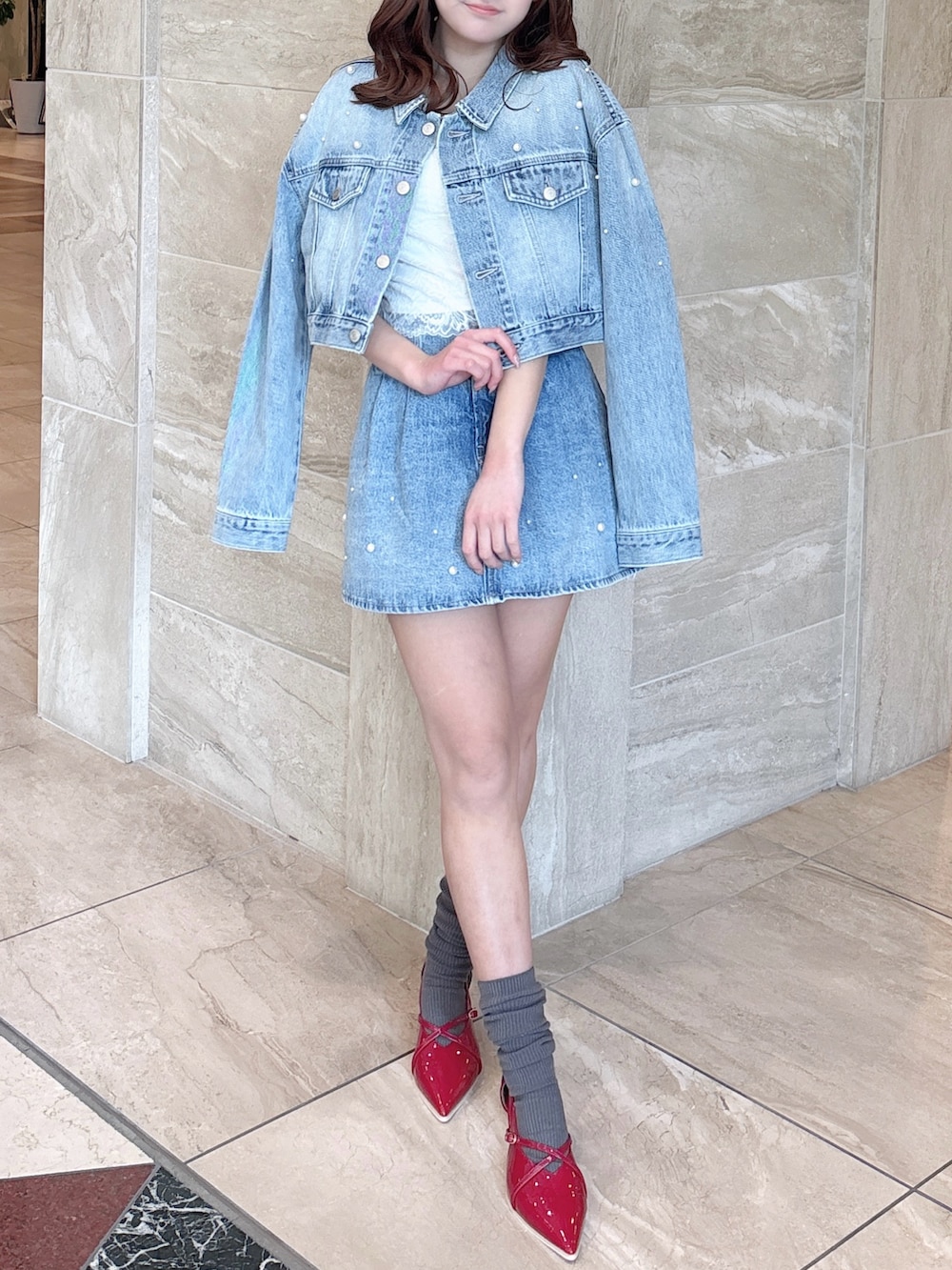 ブルー系のデニムジャケット、ブルー系のデニムパンツ、ホワイト系のキャミソールを着用したレディースの春コーディネートの6枚目の写真