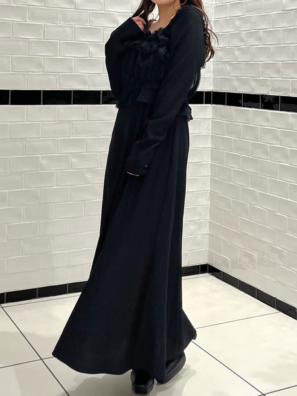 ブラック系のワンピース、ブラック系のブーツを着用したレディースの冬コーディネートの6枚目の写真