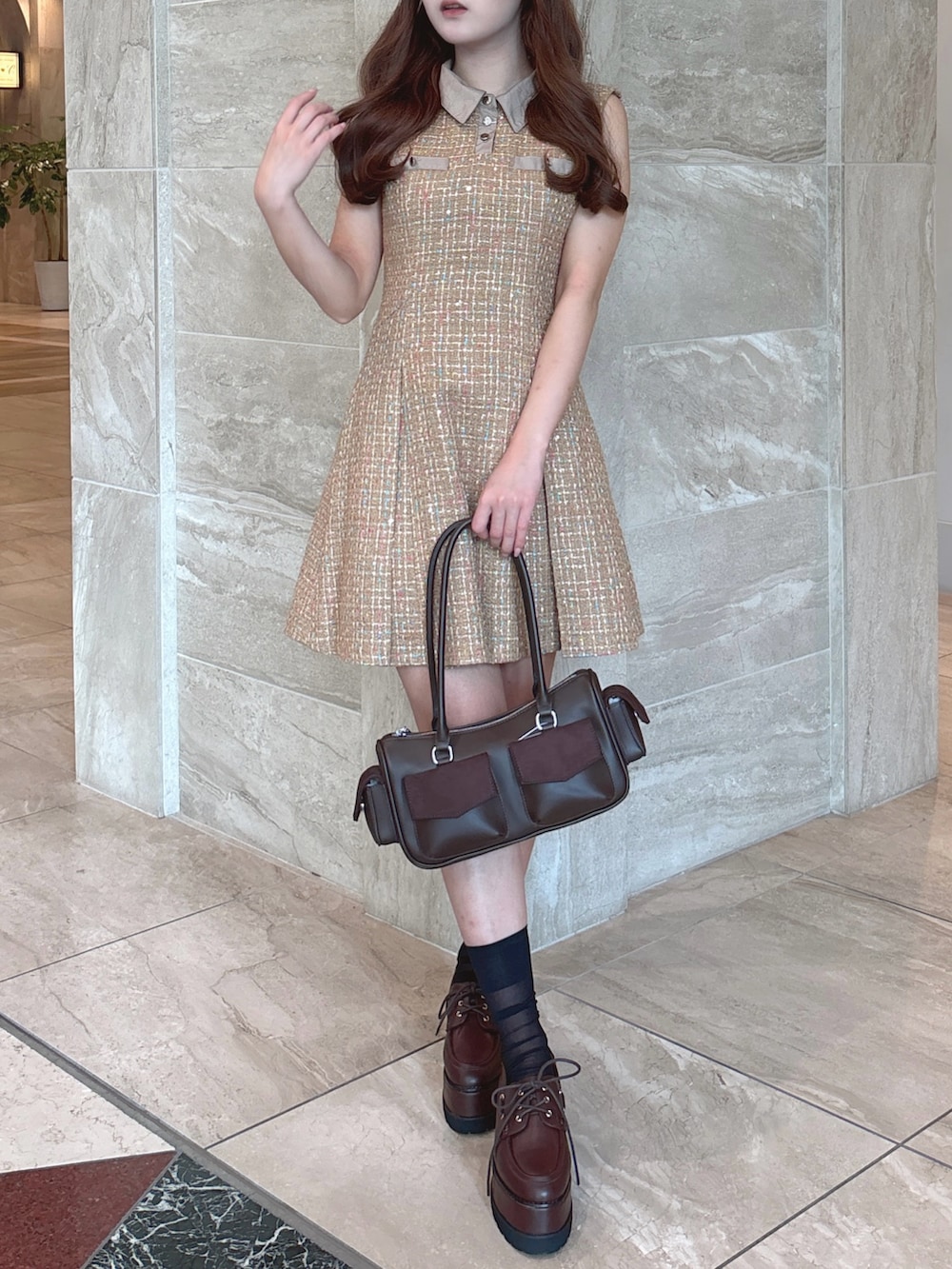 イエロー系のワンピース、ブラウン系のボストンバッグ、ブラウン系のローファーを着用したレディースの秋コーディネートの4枚目の写真