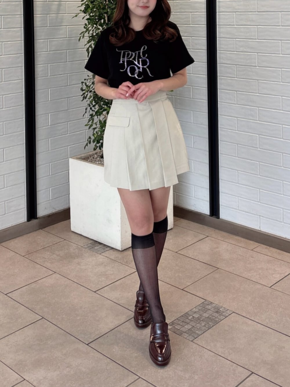 ブラウン系のパンプス、ブラック系のTシャツ/カットソー、ベージュ系のスカートを着用したレディースの夏コーディネートの5枚目の写真