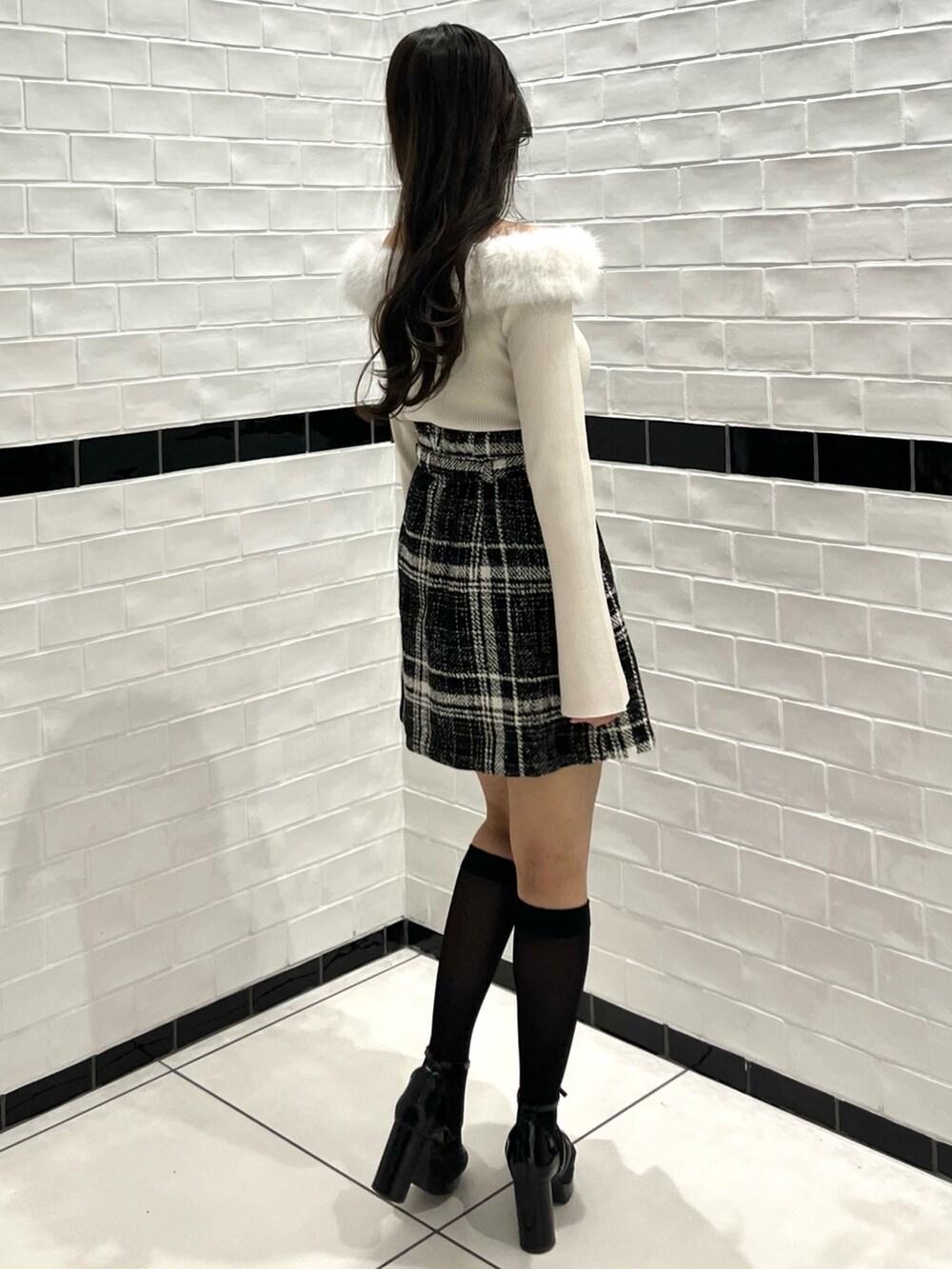 ベージュ系のニット/セーター、ブラック系のスカート、ブラック系のパンプスを着用したレディースの冬コーディネートの7枚目の写真