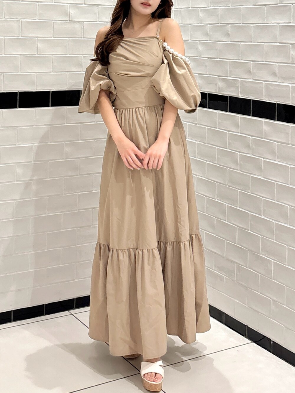 ベージュ系のワンピース、ホワイト系のサンダルを着用したレディースの夏コーディネートの2枚目の写真