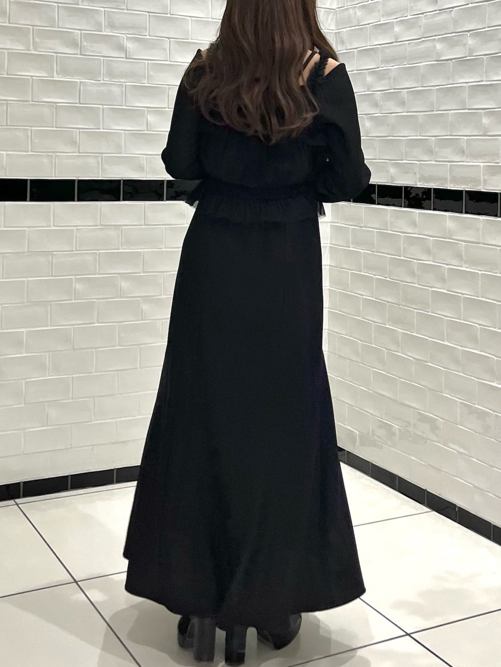 ブラック系のワンピース、ブラック系のブーツを着用したレディースの冬コーディネートの7枚目の写真