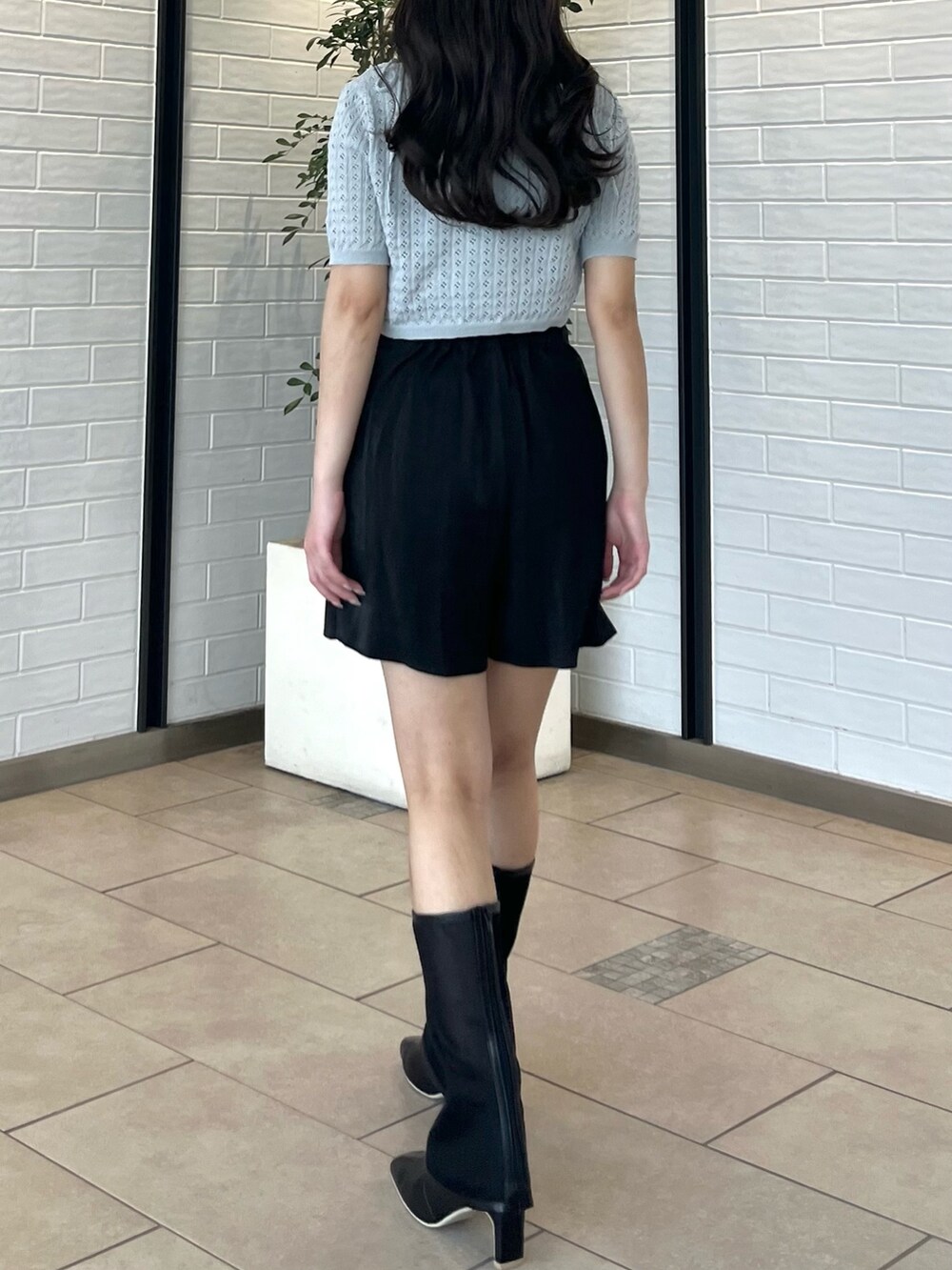 グレー系のニット/セーター、ブラック系のその他パンツ、ブラック系のブーツを着用したレディースの夏コーディネートの6枚目の写真