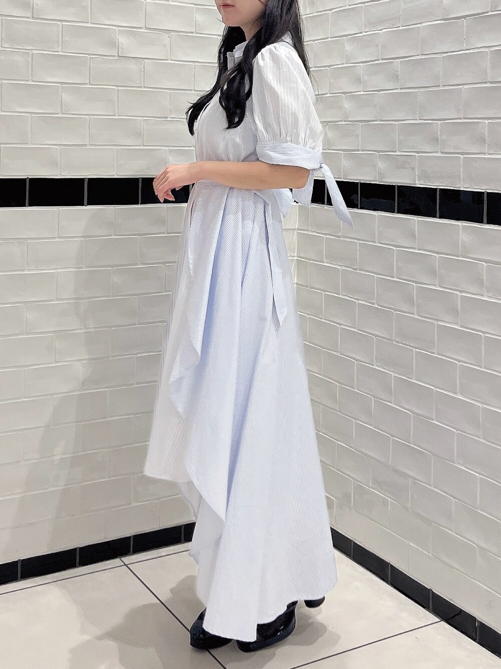 ブルー系のワンピース、ブラック系のパンプスを着用したレディースの秋コーディネートの4枚目の写真