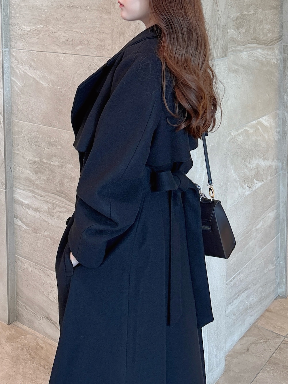 ブラック系のニット/セーター、ブラック系のスカート、ブラウン系のショルダーバッグを着用したレディースの秋コーディネートの7枚目の写真