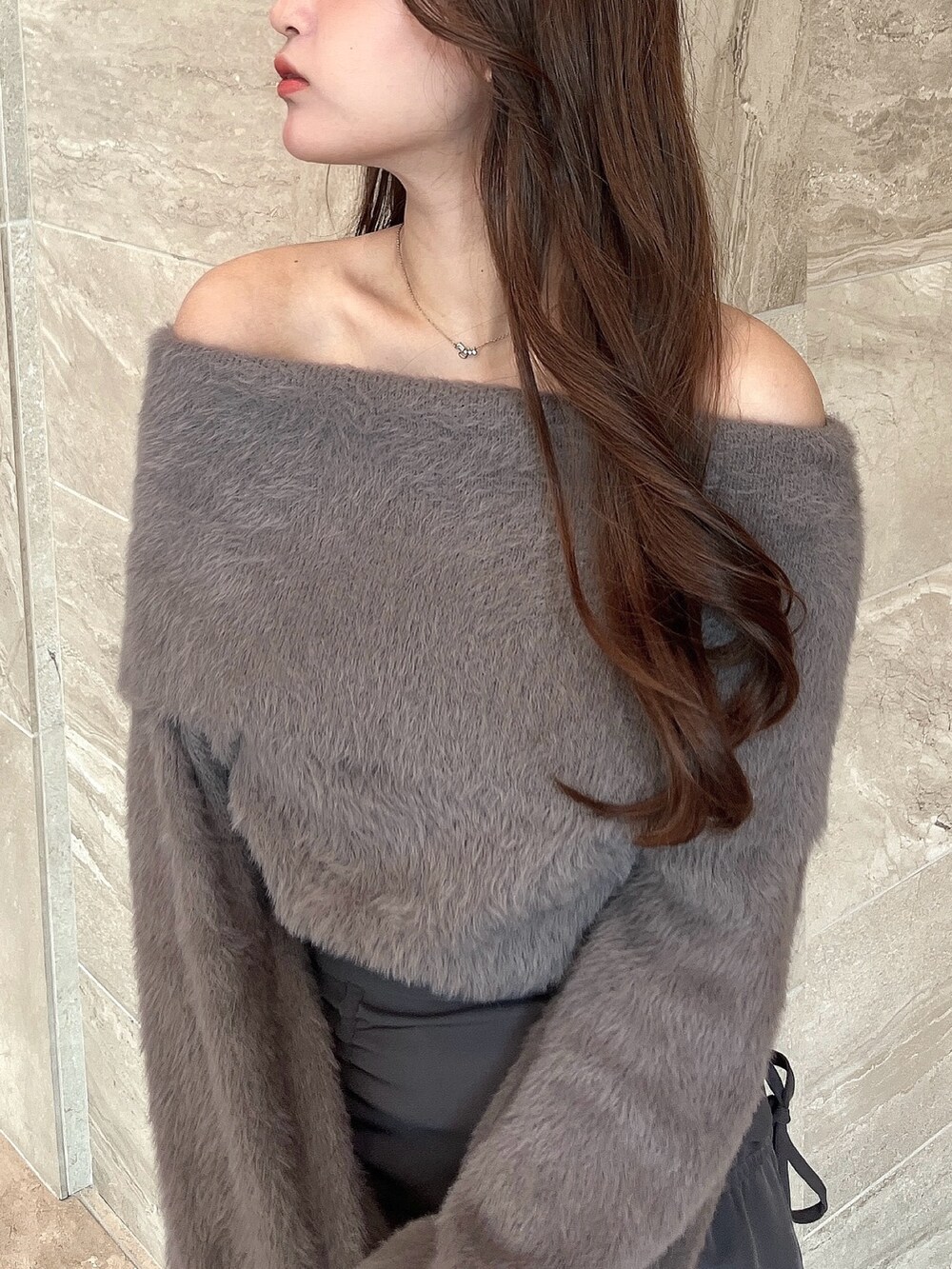 ブラウン系のニット/セーター、グレー系のスカート、その他のブーツを着用したレディースの冬コーディネートの10枚目の写真