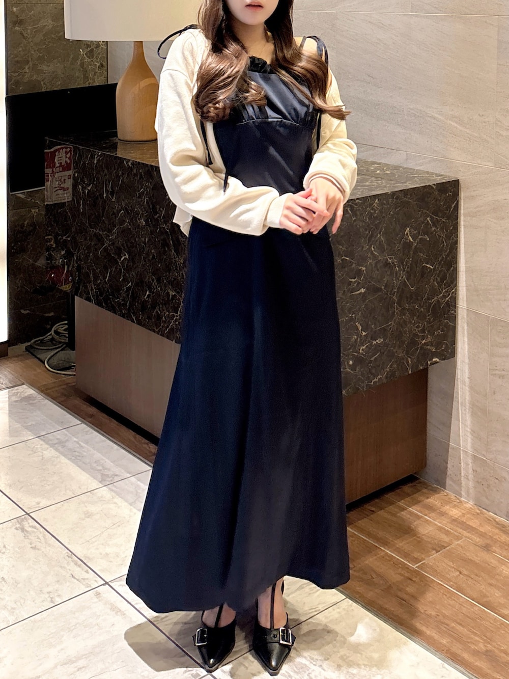 ブルー系のワンピース、ホワイト系のカーディガン/ボレロ、ブラック系のパンプスを着用したレディースの秋コーディネートの4枚目の写真