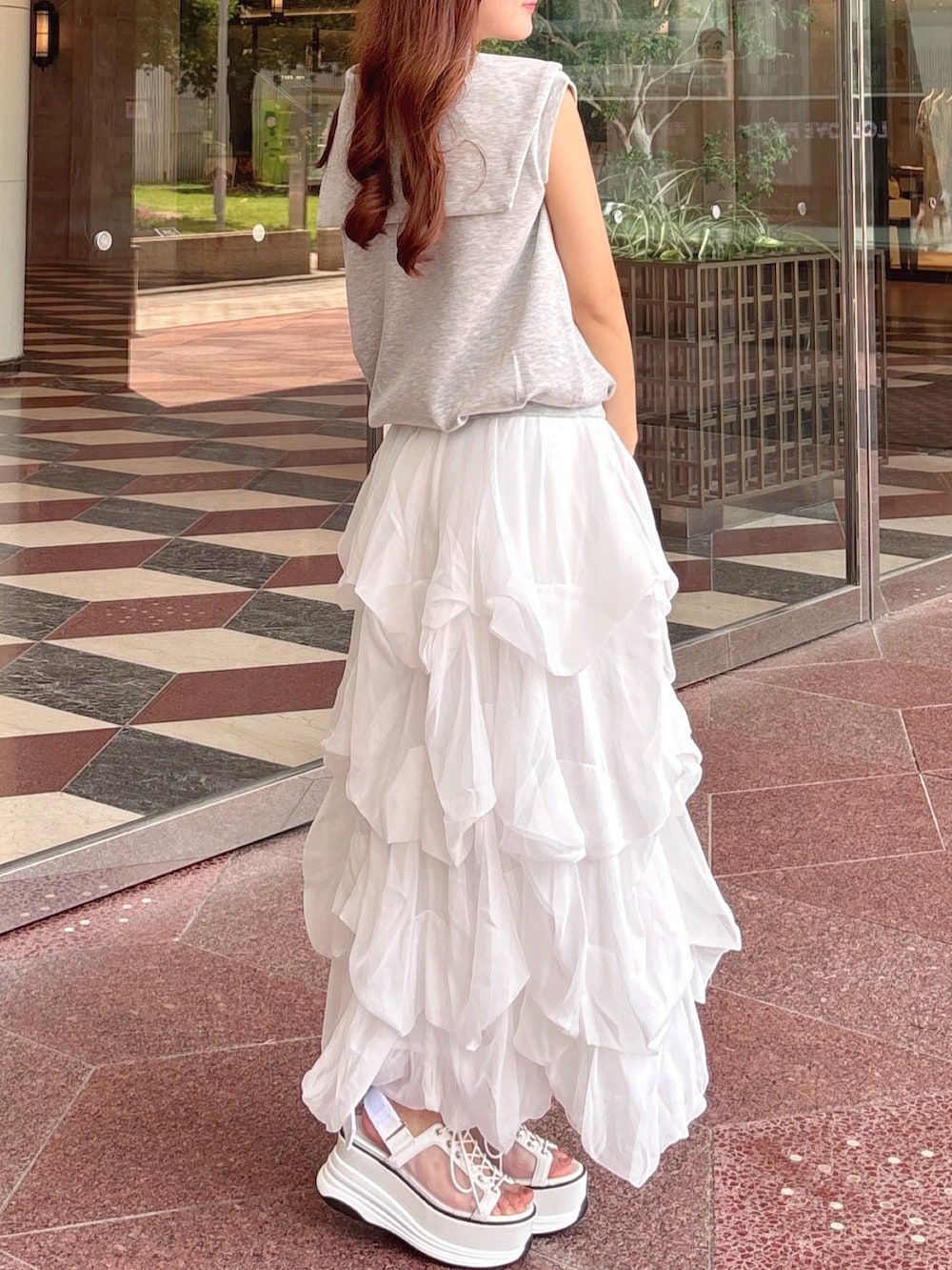 グレー系のTシャツ/カットソー、ホワイト系のスカート、ホワイト系のボストンバッグを着用したレディースの夏コーディネートの7枚目の写真