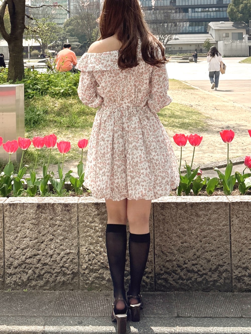 オレンジ系のワンピース、ブラウン系のローファーを着用したレディースの春コーディネートの9枚目の写真