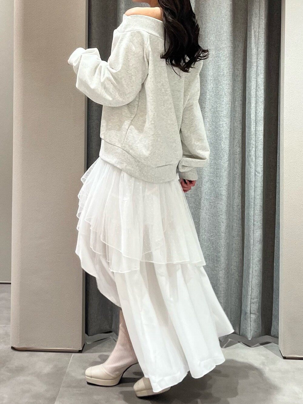 グレー系のスウェット、ホワイト系のスカート、ホワイト系のブーツを着用したレディースの春コーディネートの5枚目の写真